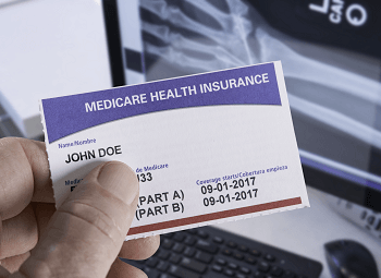 Person holding a medicare insurance card with coverage for part a and part b